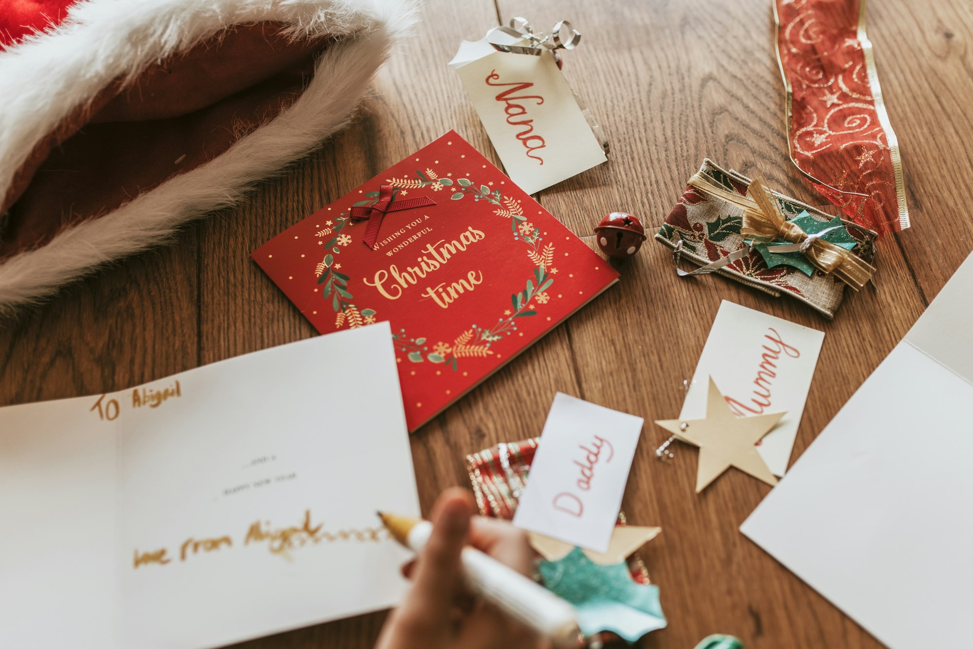 Kids writing Christmas cards on wooden floor